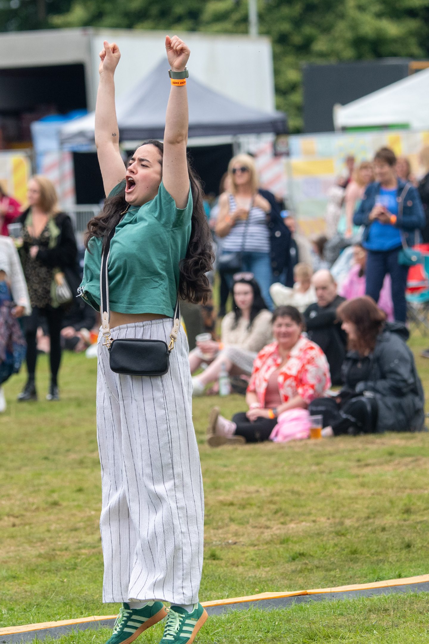 A festival-goer cheering on the entertainment. 