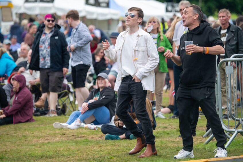 Two men singing along to performer 