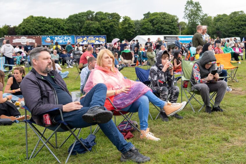 People sitting on camping chairs at festival 