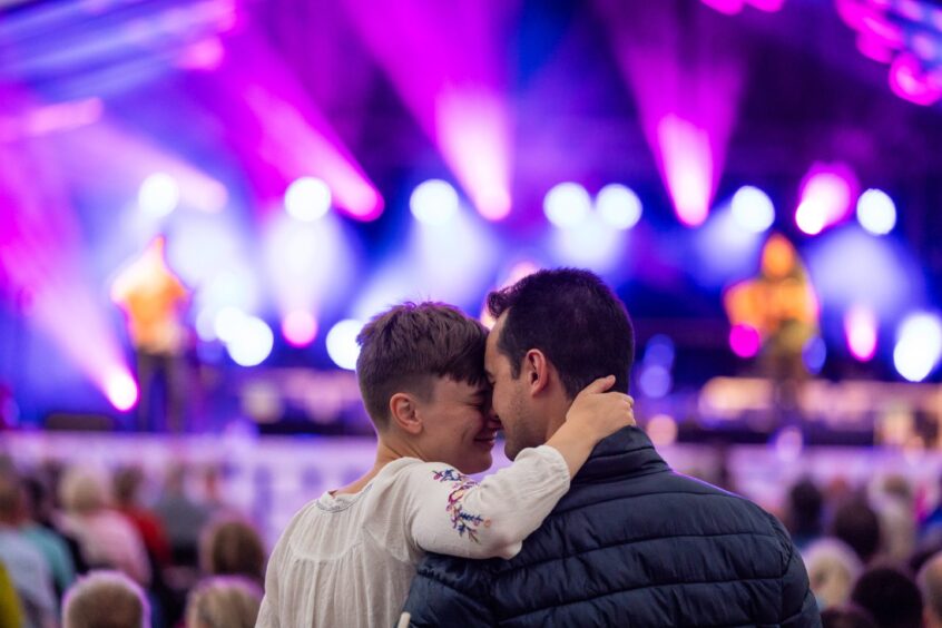 Couple in a loving embrace in front of the main stage.