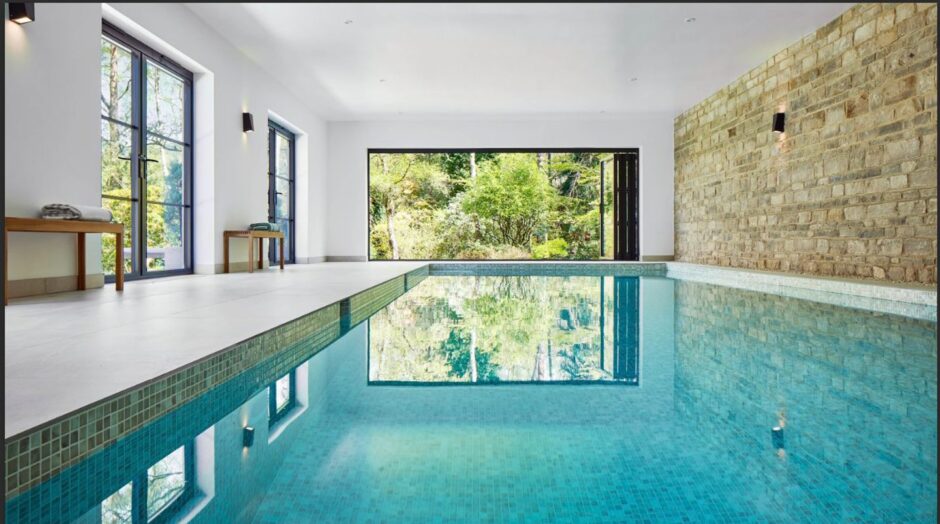 View of the indoor pool with brick wall and natural daylight flooding in.