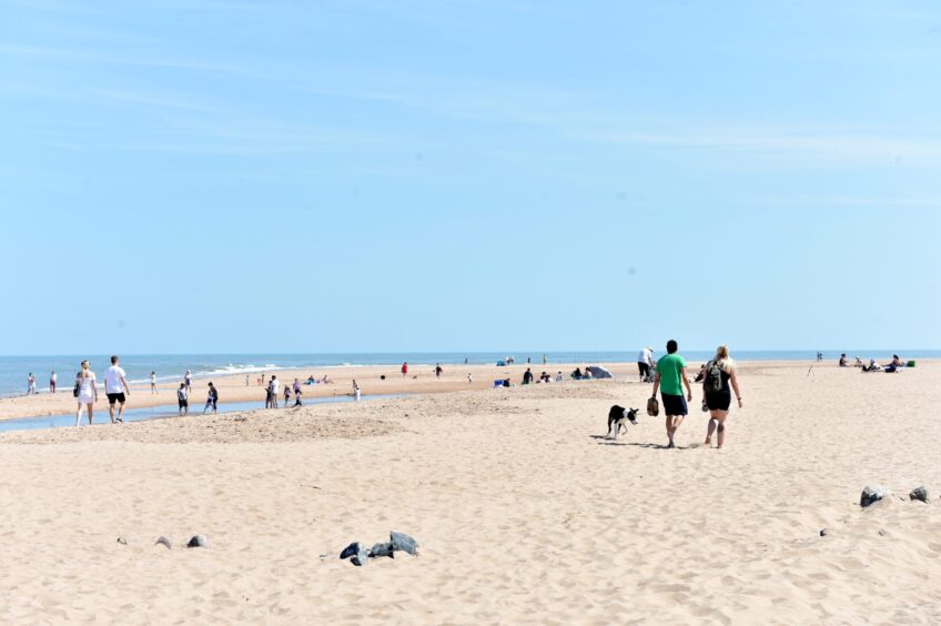 People walking along Newburgh Beach, which is a fine picnic spot in Aberdeenshire