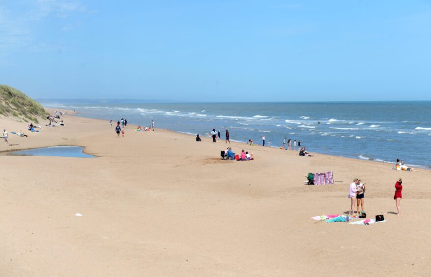 People on Balmedie Beach on a sunny day.