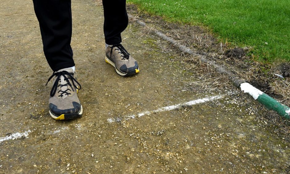 Close-up of two feet on Elgin running track surface. 