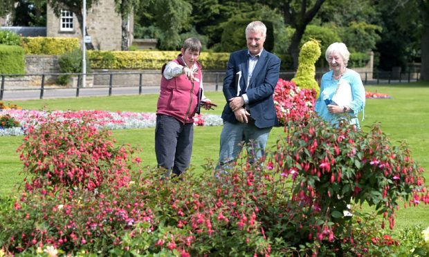 Britain in Bloom judges Geraldine King and Nick Jones pointing at flower display in Grant Park.