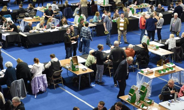 people sit at tables as the count is conducted in Dingwall for a seat in the 2024 General Election