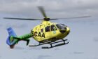 Yellow helicopter with green tail belonging to SCAA.