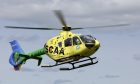 Yellow helicopter with green tail belonging to SCAA.