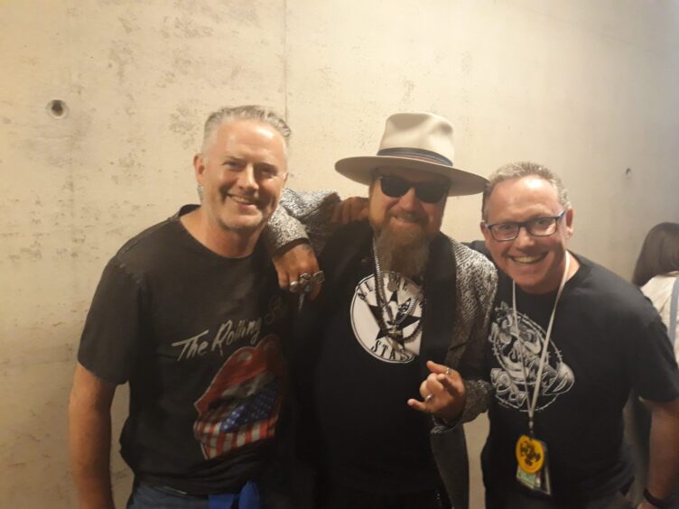 Superfan Iain Monk with his twin brother Colin and Lynyrd Skynyrd's Peter Keys, in June 2019 at the OVO Hydro in Glasgow, 2019