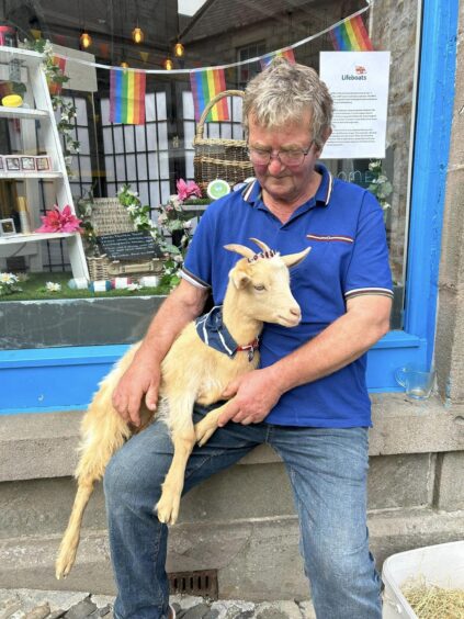 Little Miss Goatee and owner Tom, wearing a blue polo shirt.