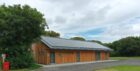 Facilities block with wooden panels and solar panels on the roof.