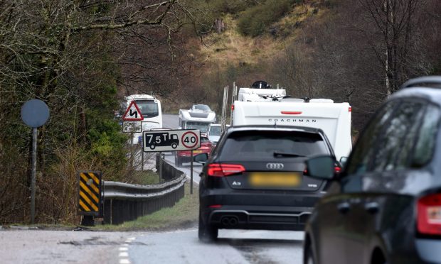 Traffic on the A82 including a black car and a motorhome.