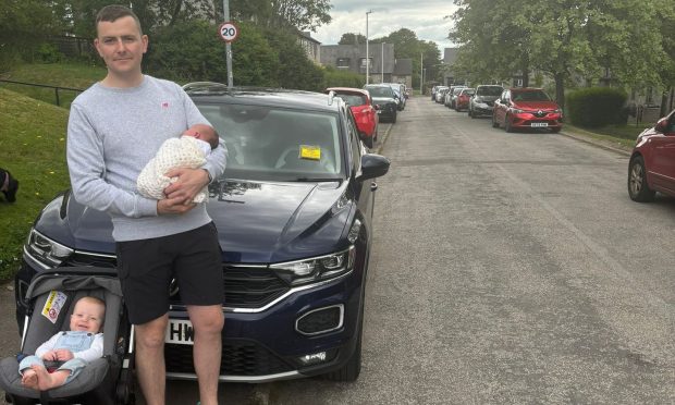 Craig Watson in front of car with children.