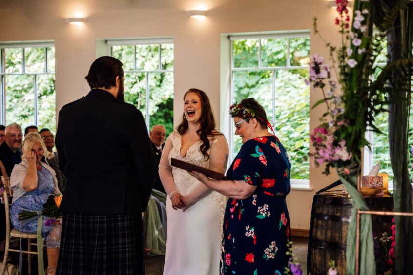 A couple laughing at a wedding with Isabel Lockhart.