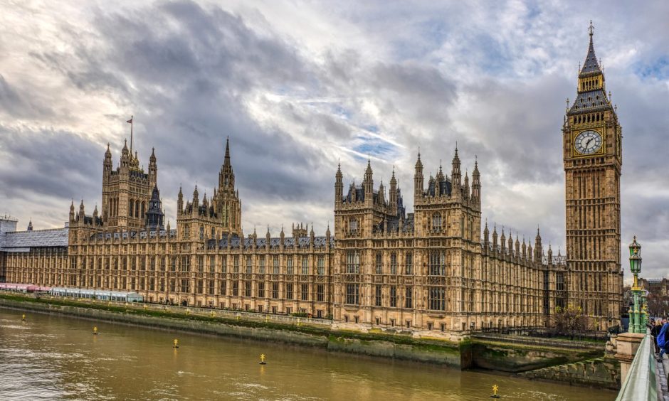 View of UK Houses of Parliament from bridge on Thames. 