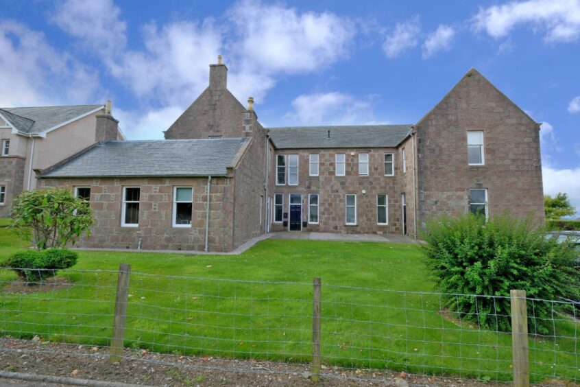 Exterior of the granite building that has been converted into flats. 