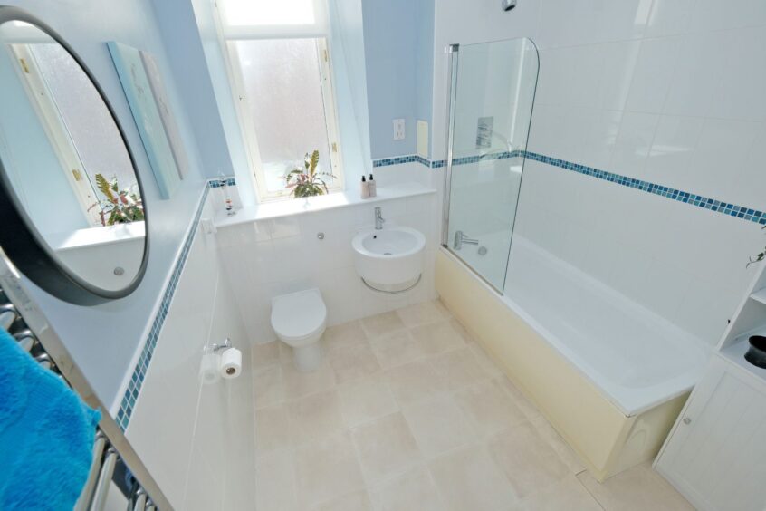 Bright bathroom at the Aberdeen flat for sale, featuring circular porcelain basin attractive tiling.