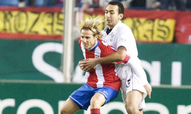 Karim Touzani, right, wrestles with Atletico Madrid's Diego Forlan. Image: SNS.