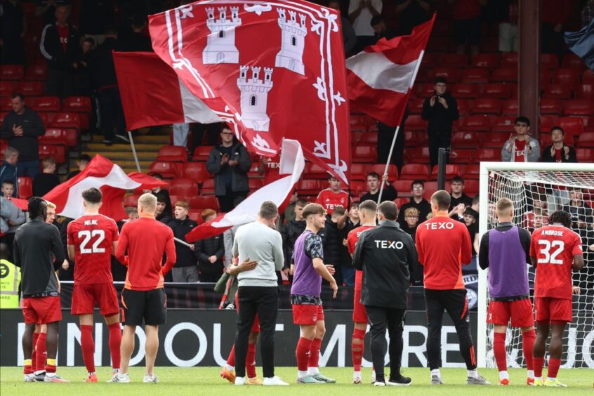 Aberdeen players and Aberdeen manager Jimmy Thelin applaud the fans after the Premier Sports Cup defeat of Queens Park at Pittodrie. Image: Shuttestock