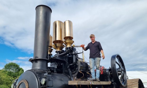 Apprentice Findlay Lawson from Netherley, Stonehaven stands aboard steam tractor Erebus, ready to sound the reproduction Titanic whistles mounted behind the funnel. Image: Susy Macaulay/DCT Media.
