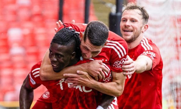 Aberdeen's Pape Habib Gueye (L) celebrates scoring to make it 1-0 with Ester Sokler and Nicky Devlin against Kilmarnock. Image: SNS