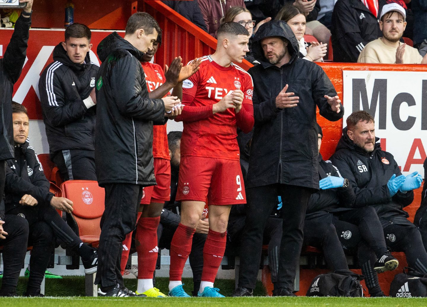 Aberdeen's Kevin Nisbet (centre) speaks to manager Jimmy Thelin as he prepares to come on to make his debut against Kilmarnock. Image: SNS