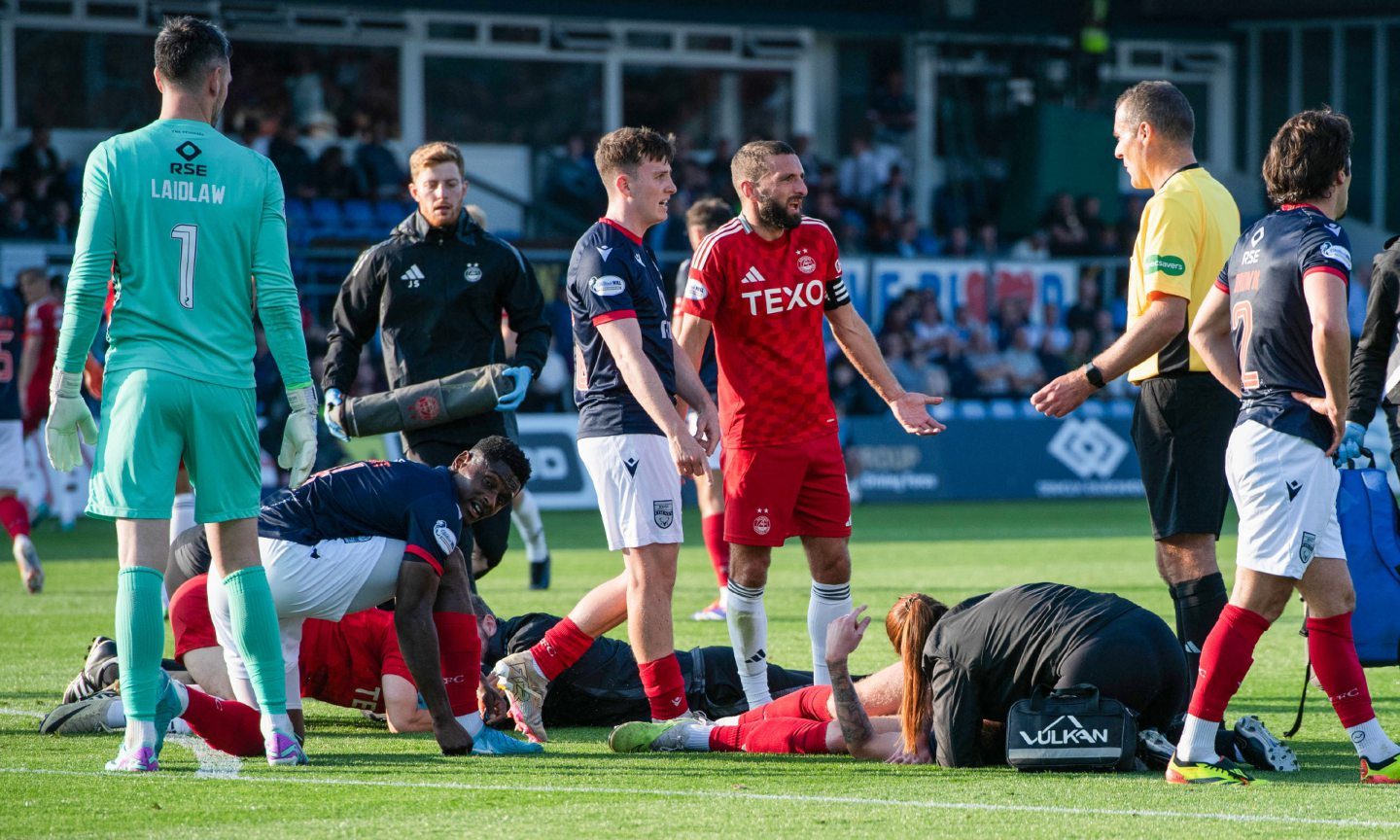 Aberdeen's Jamie McGrath and Ross County's Kacper Lopata go down after a head collision. Image: SNS