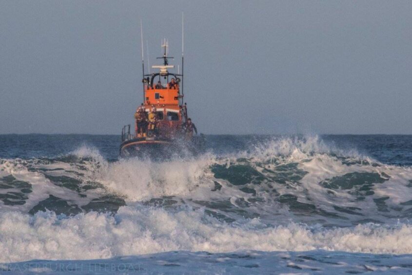 Fraserburgh Lifeboat in the distance amidst waves.