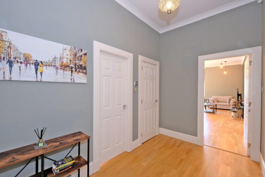 Bright hallway at the Aberdeen flat for sale, featuring light oak laminate flooring.