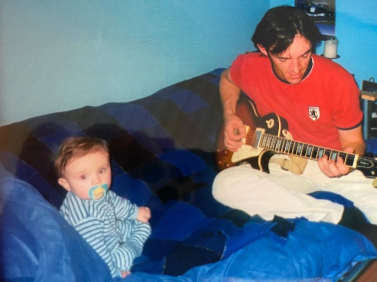 My dad strumming away to me as a baby. Image: Isaac Buchan/ DC Thomson