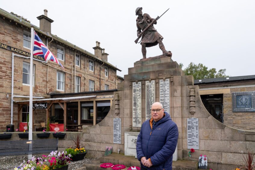 Andrew in front of one of Dingwall's war memorials, with the National Hotel in the background.