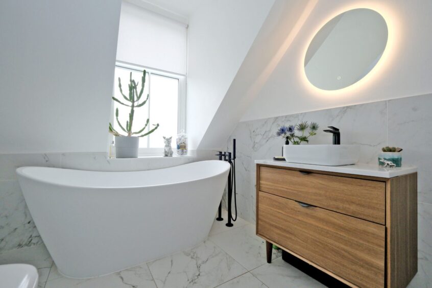 Bathroom at the Rosemount home renovation, featuring a freestanding tub and black fixtures.