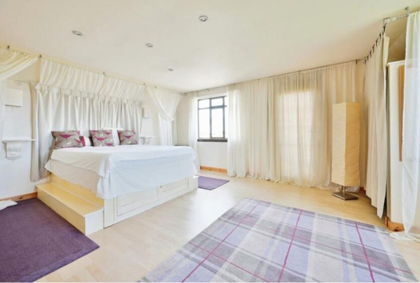 Bedroom with large bed on a platform.