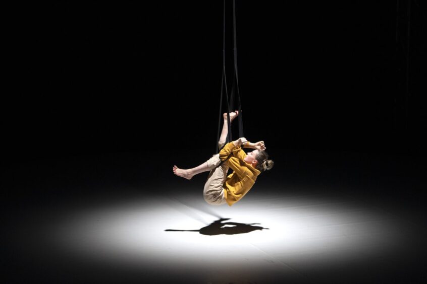 Performer twisting into a contortion pose