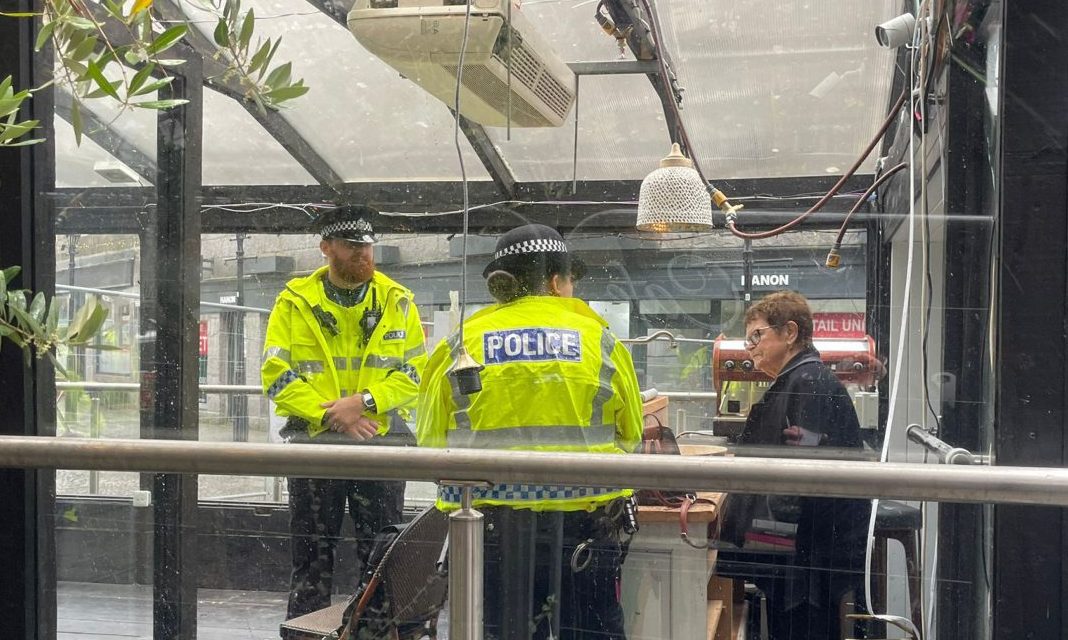 Police officers and Dorothy Bothwell as the Cafe 52 pavilion demolition scheme progresses.