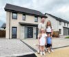 Sutherland family stands in front of their home, one of many houses in Aberdeenshire