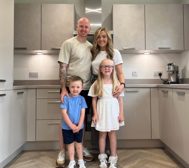 Sutherland family stands inside the kitchen in their new CHAP home, chosen among the many houses in Aberdeenshire 