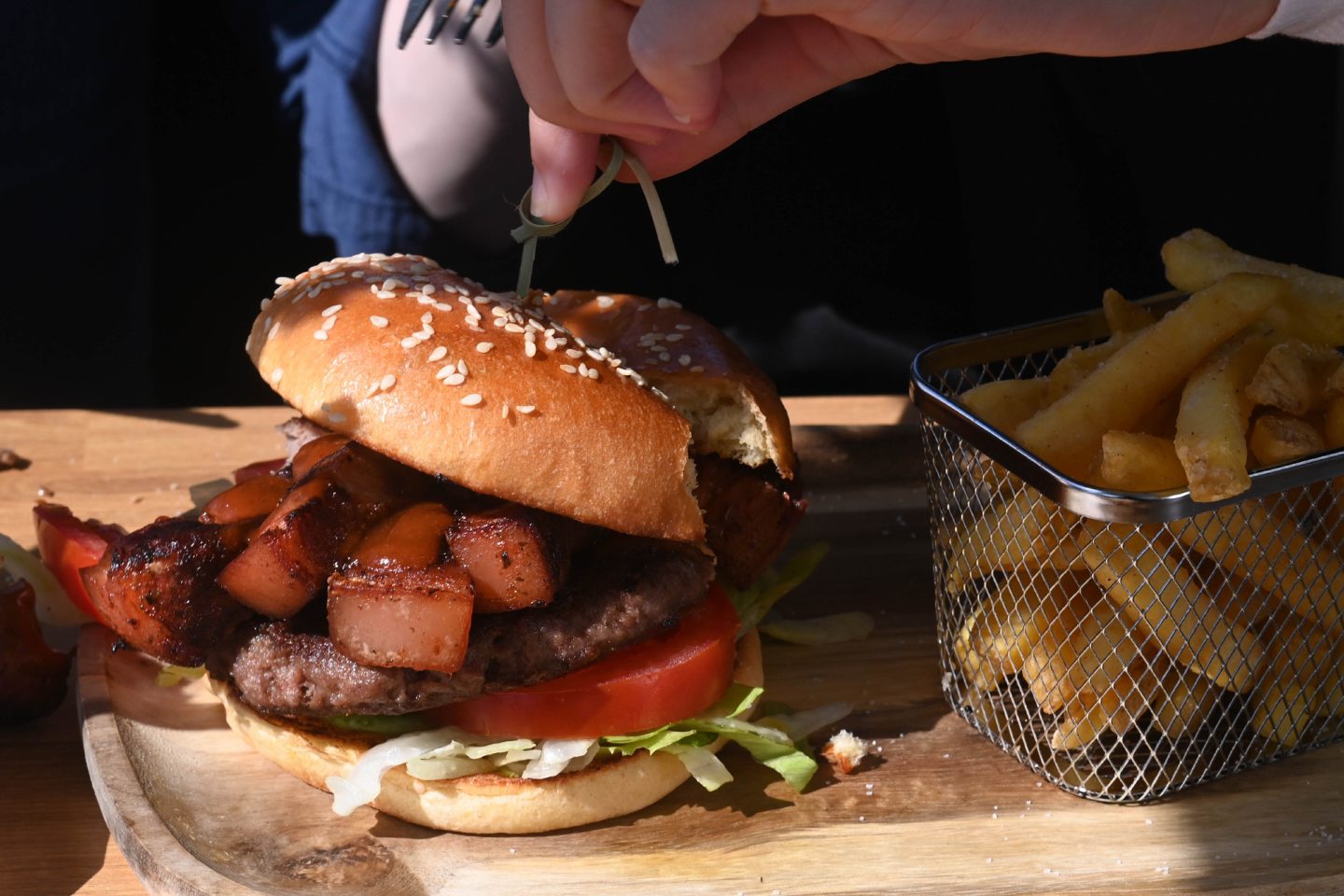 Slicing into the burger.