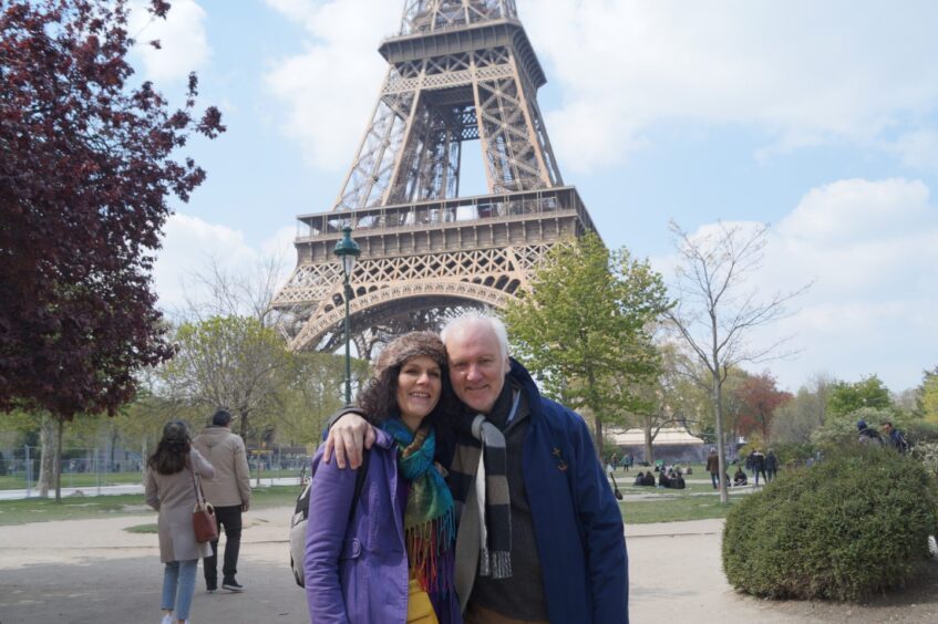 Angus Peter and his wife Lionsaidh in Paris below the Eiffel Tower.