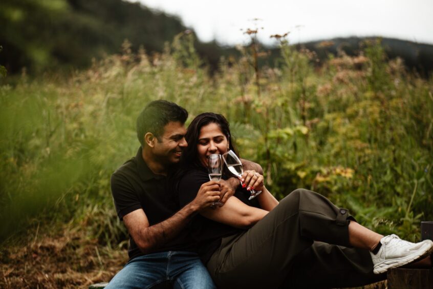 The newly-engaged couple with their glasses of champagne. 