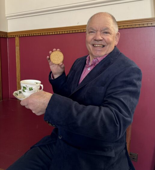 Alan James holding digestive biscuit. 