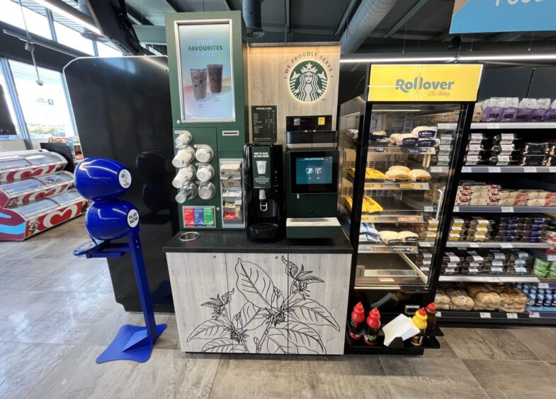 Starbucks self-service beside a Rollover hotdog stand. 