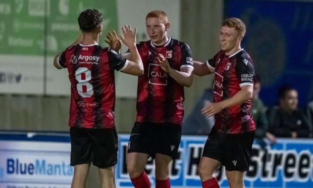 Aidan Wilson, centre, celebrates scoring Inverurie Locos' third goal against Turriff United in the Highland League. Pictures by Jasperimage.