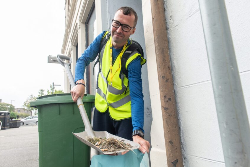 Mike Duncan dropping waste in bag. 