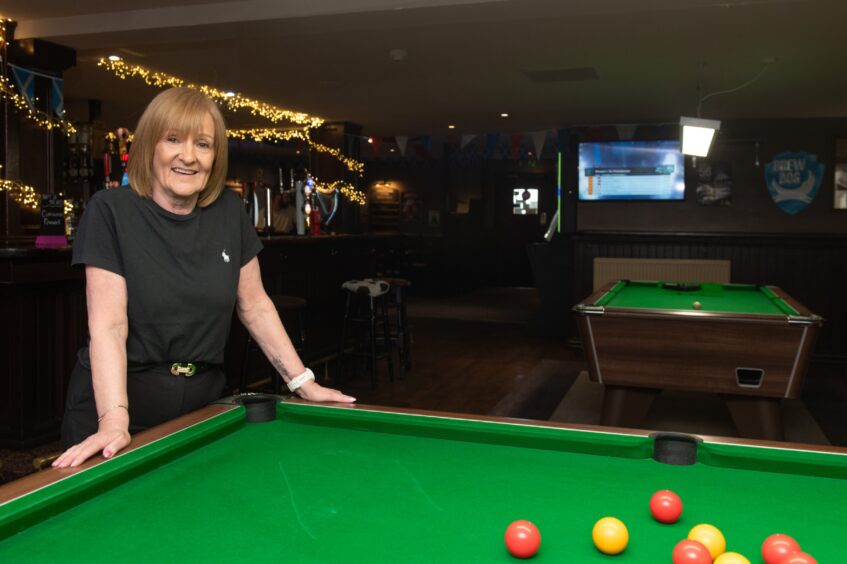 Liz Lawson at a pool table at the Inverness hotel.