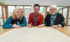 Alison Mason, Alasdair MacDonald and Anne Fraser study the family tree. Image Jason Hedges/DC Thomson