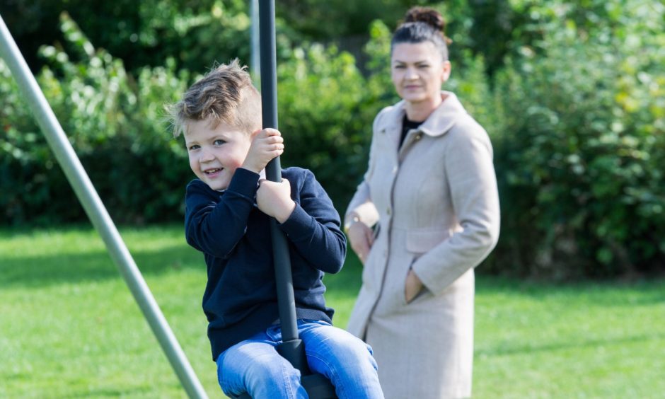 Kristian on zipline with mum Kristina behind. 