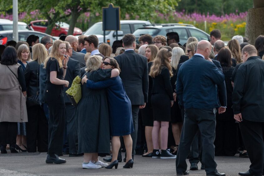 People hugging outside Aberdeen Crematorium at Liz Milne's funeral. 