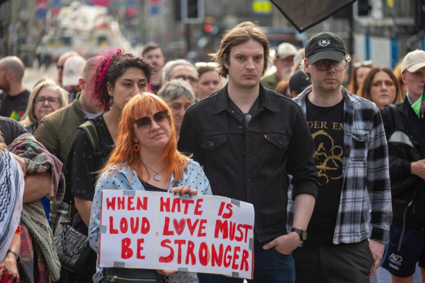 People standing listening to protest speakers