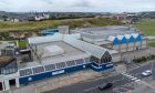 The boarded up Beach Leisure Centre at Aberdeen seafront, with Pittodrie football stadium in the background. Image: Kenny Elrick/DC Thomson